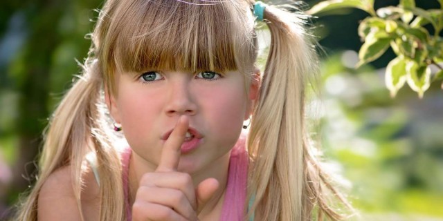 Niña pidiendo silencio