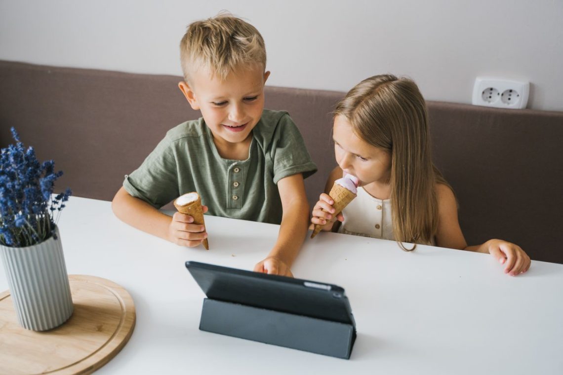 Niños utilizando una tablet en verano como ejemplo de uso saludable de pantallas y tecnología