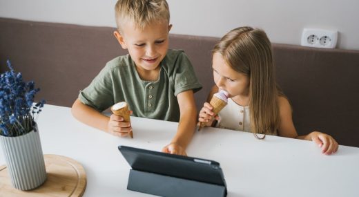 Niños utilizando una tablet en verano como ejemplo de uso saludable de pantallas y tecnología