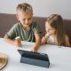 Niños utilizando una tablet en verano como ejemplo de uso saludable de pantallas y tecnología